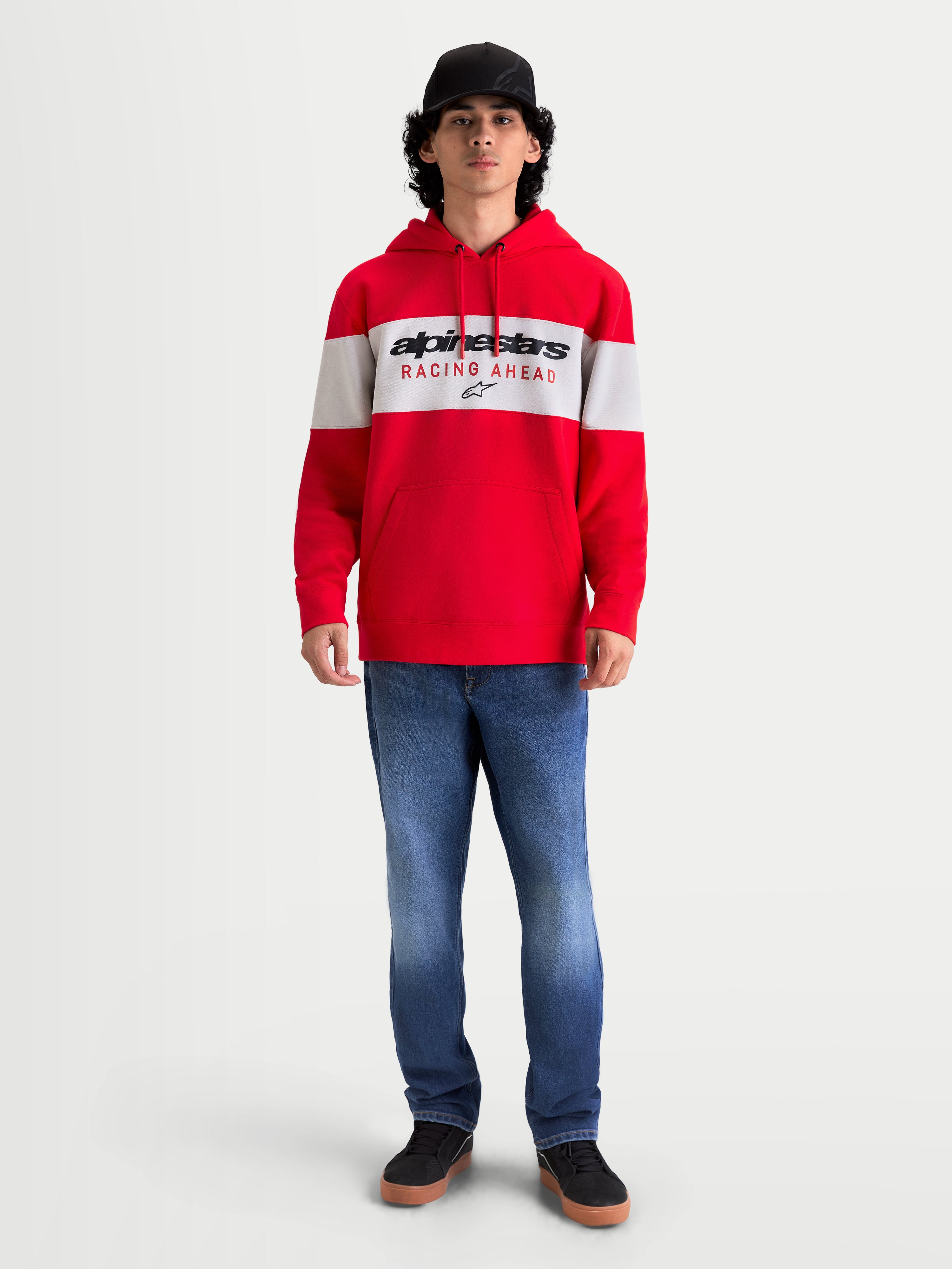 Alpinestars Sudadera con capucha Cubic, sudadera de forro polar roja y blanca, con diseño en bloques de color y logotipo Alpinestars Racing Ahead en el pecho. Vista en modelo con un ajuste casual de estilo motorsport, capucha con cordón y puños de canalé para uso fuera de la moto.