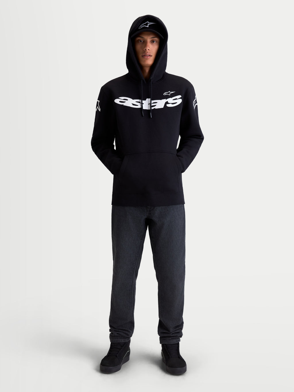Alpinestars Sudadera con capucha Velocifier, sudadera de estilo casual inspirado en el motorsport, negra y blanca, con logotipo Astars en el pecho y en los hombros, mezcla de algodón y poliéster reciclado, vista frontal en modelo.