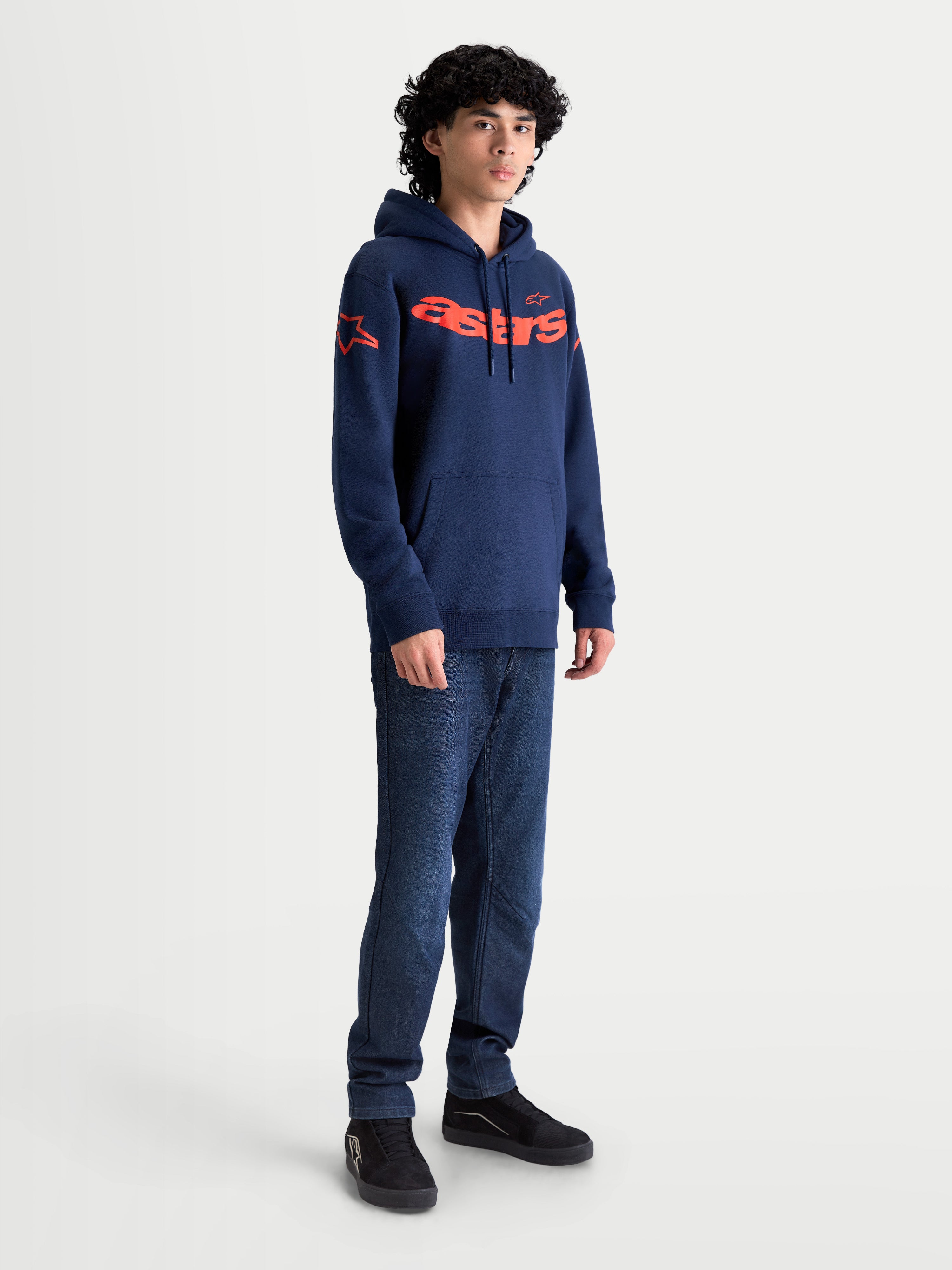 Alpinestars Sudadera con capucha Velocifier, sudadera de forro polar para hombre, azul marino y naranja, con logotipo astars en el pecho y los hombros, estilo casual inspirado en el motorsport, mostrada en modelo.