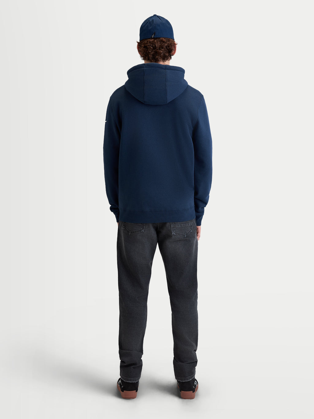 Alpinestars Sudadera Con Capucha Race Wordmark, sudadera de forro polar para uso casual, vista trasera en modelo, azul marino, confeccionada en mezcla de algodón y poliéster reciclado con capucha forrada y dobladillo de canalé.
