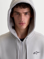 Alpinestars Entity Oversized Hoodie, Sportswear Zip-Up Fleece for Men and Women, Cement Gray, features a Vislon front zipper and embroidered Astars logo, shown in a close-up on-model portrait with the hood up.