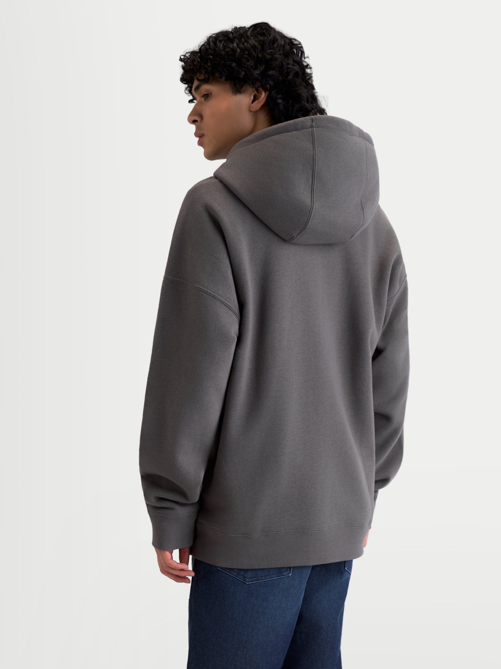 Alpinestars Sudadera con capucha Entity Oversized, sudadera de forro polar gris carbón, vista trasera en modelo mostrando silueta holgada y bajo de canalé, ropa casual de estilo sportswear