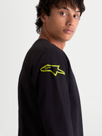 Alpinestars Velocifier CSF, camiseta de mangas largas para hombre, negra con un logotipo Astars amarillo vibrante en el hombro, ropa deportiva casual de estilo motorsport, vista de cerca en modelo