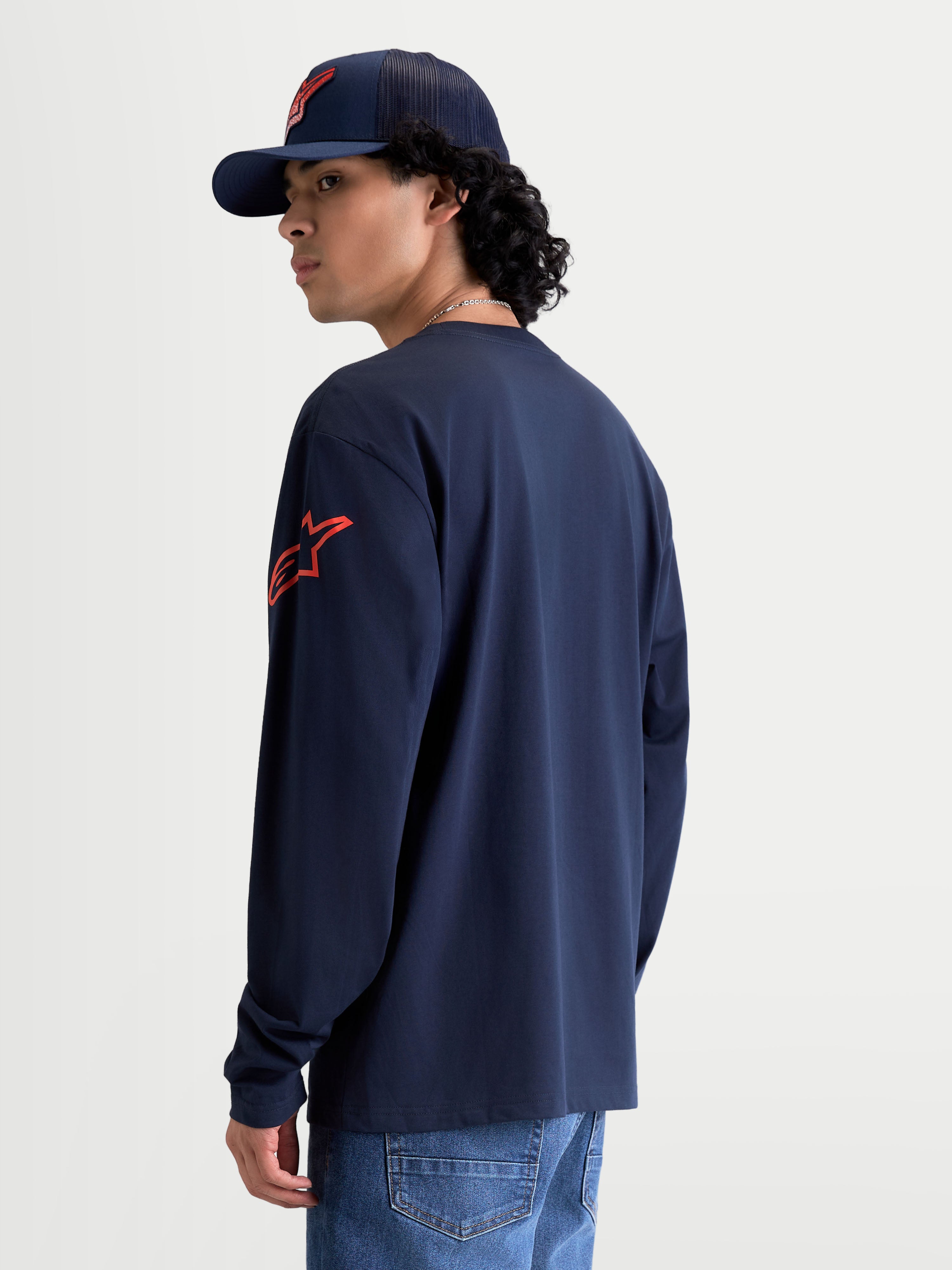 Alpinestars Velocifier CSF, camiseta de mangas largas de ropa deportiva para hombre, azul marino y roja, con logotipo Astars rojo en el hombro, vista trasera en modelo, confeccionada en 80% algodón y 20% poliéster reciclado.
