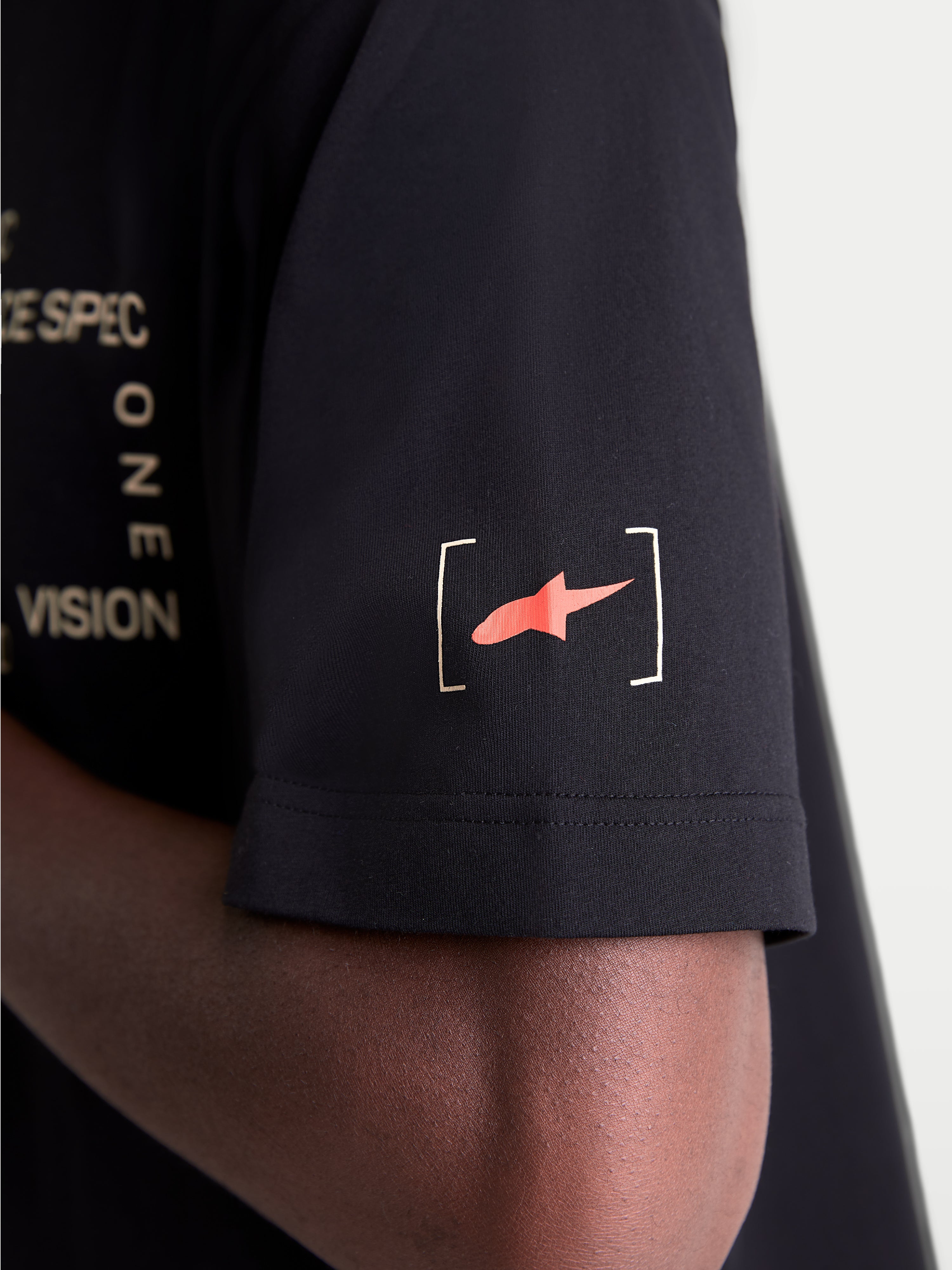 Alpinestars Infinity Oversized CSF Tee, Casual Sportswear T-shirt, Black and Red, close-up view of the short sleeve featuring the Astars bracket logo and part of the 'ONE VISION' front graphic detail, premium off-bike style.