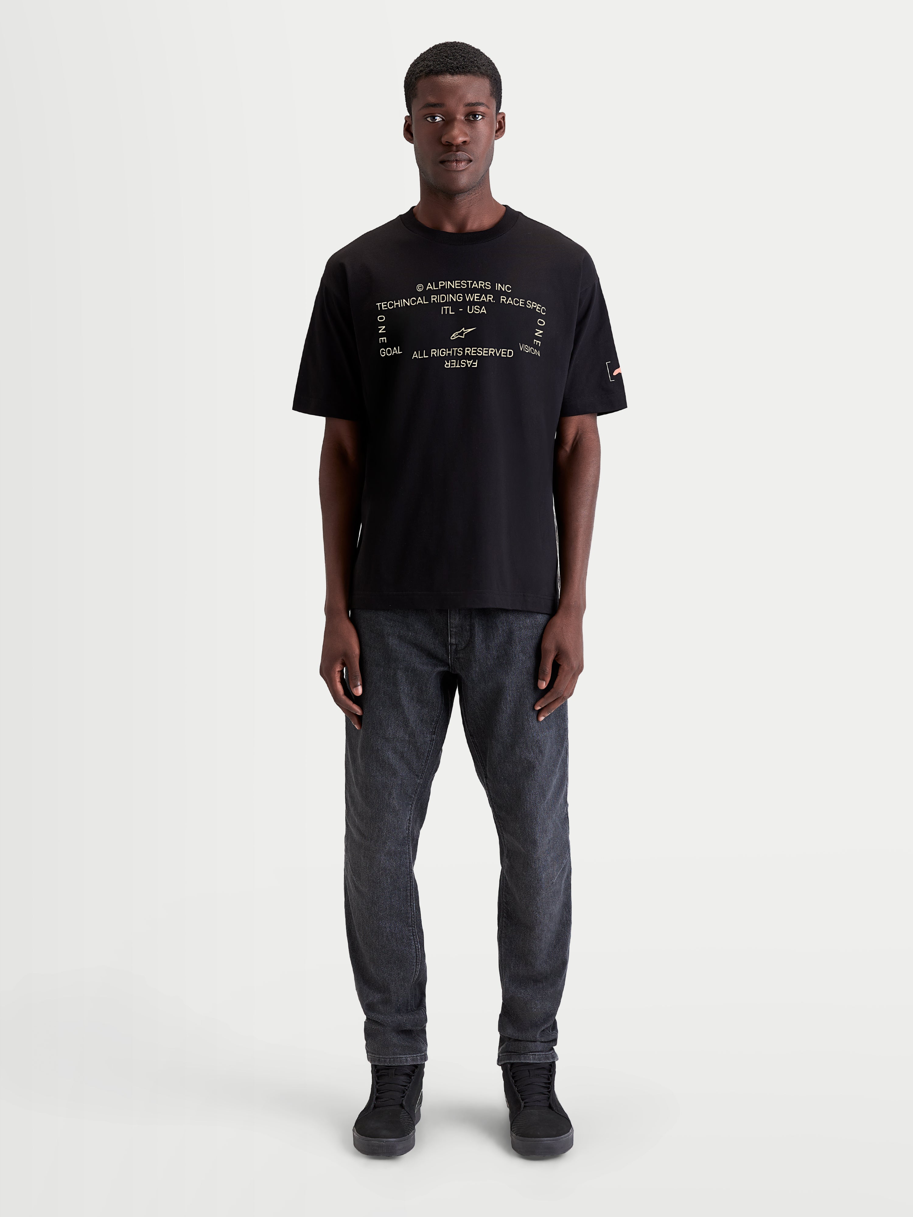 Alpinestars Infinity Oversized CSF Tee, Black Short Sleeve Sportswear T-Shirt for Men and Women, on-model view featuring a white technical text graphic on the chest, oversized fit for casual off-bike style, soft-hand cotton-poly blend.