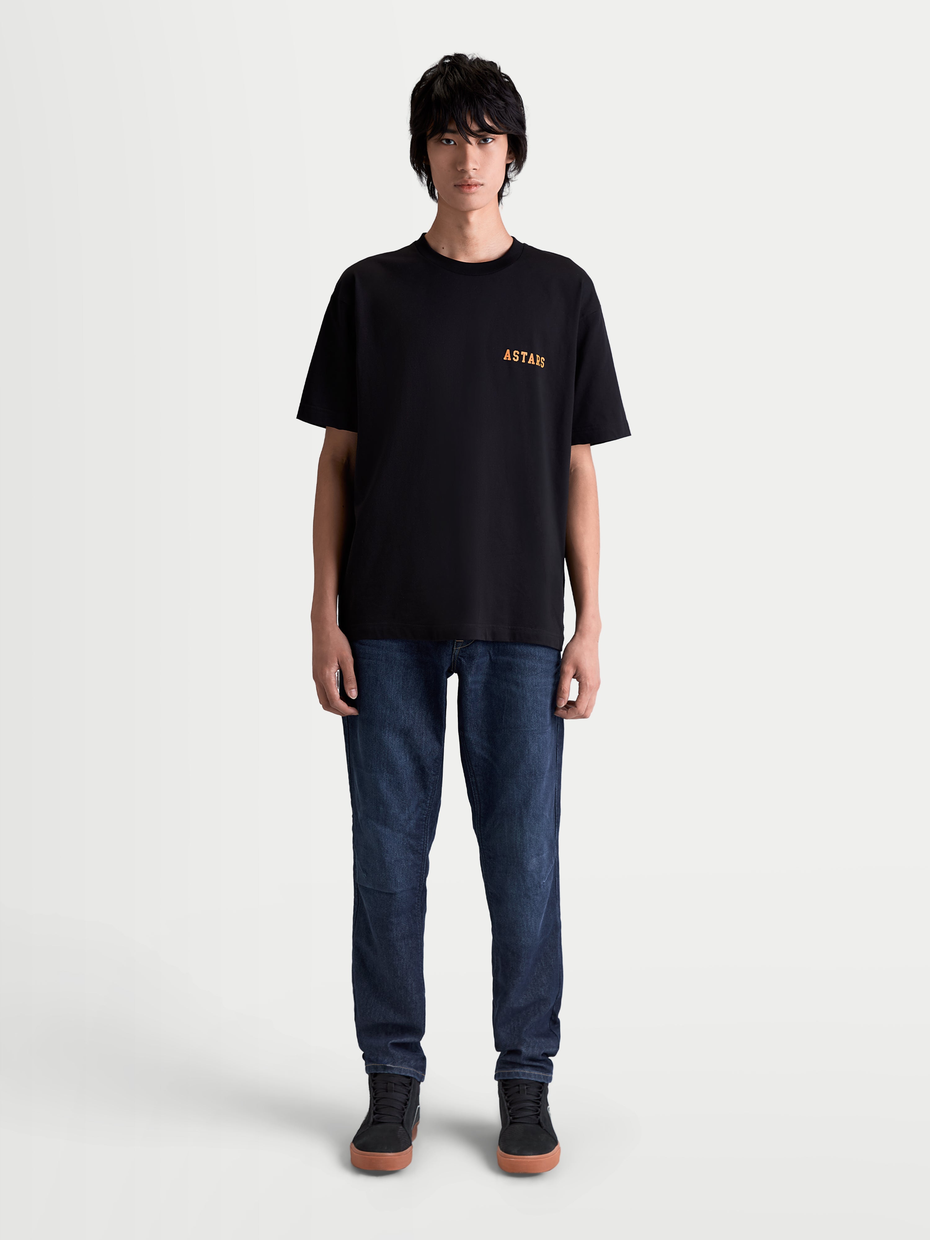 Alpinestars Latitude Oversized CSF Tee, Short Sleeve Sportswear T-shirt, Black and Orange, relaxed oversized fit, premium cotton-poly blend, featuring ASTARS chest graphic on model.