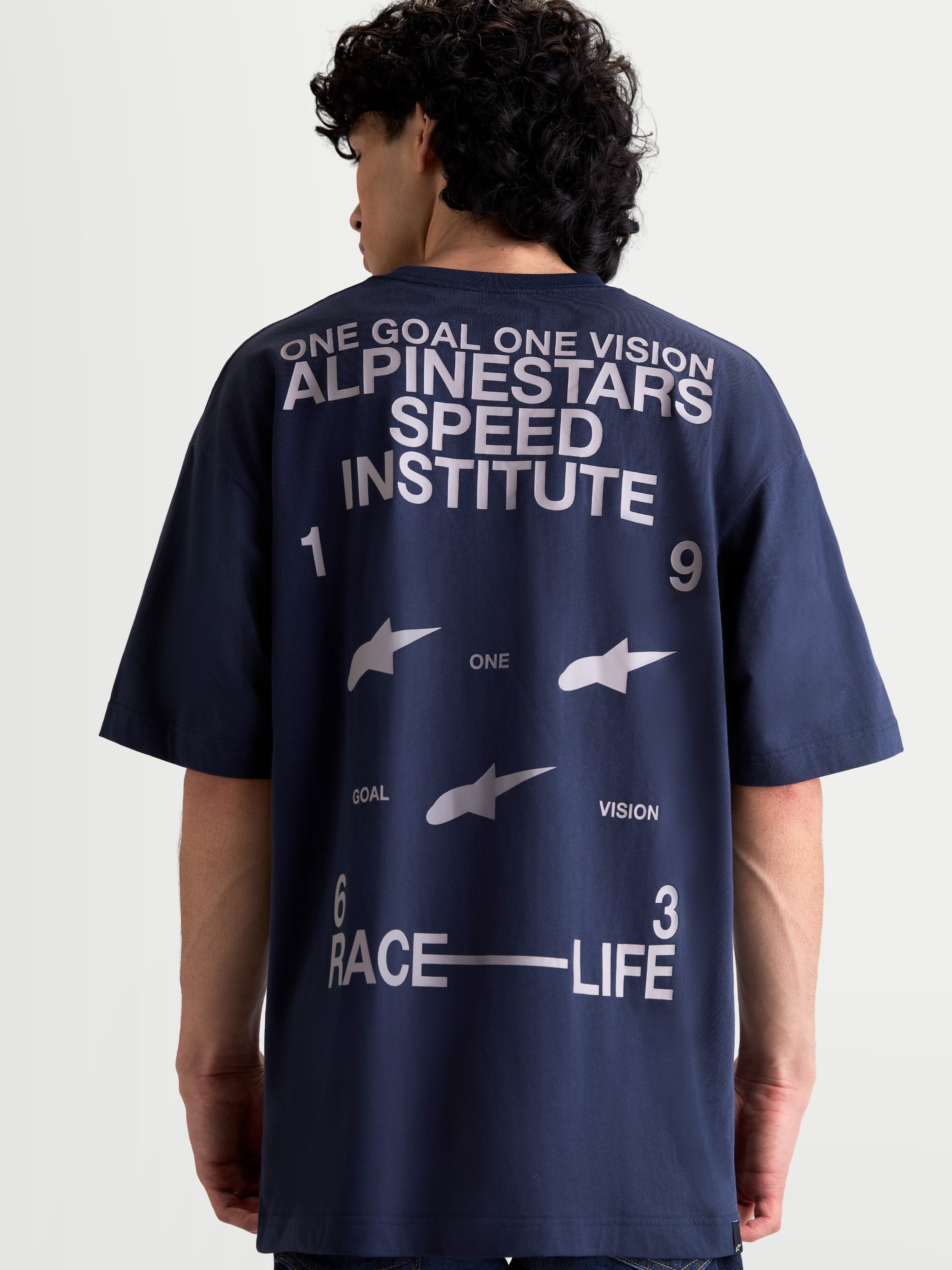 Alpinestars Institute Oversized CSF Tee, Navy Blue and White Sportswear T-Shirt, back view showing large Speed Institute and One Goal One Vision graphics, relaxed oversized fit cotton-poly blend.