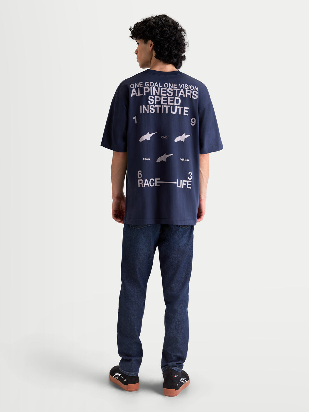 Alpinestars Institute Oversized CSF Tee, Navy Blue Sportswear Short Sleeve T-Shirt, featuring a large white back graphic with 'Alpinestars Speed Institute' text, 'One Goal One Vision' slogan, and 'Race Life' branding, relaxed oversized fit, back view on model.