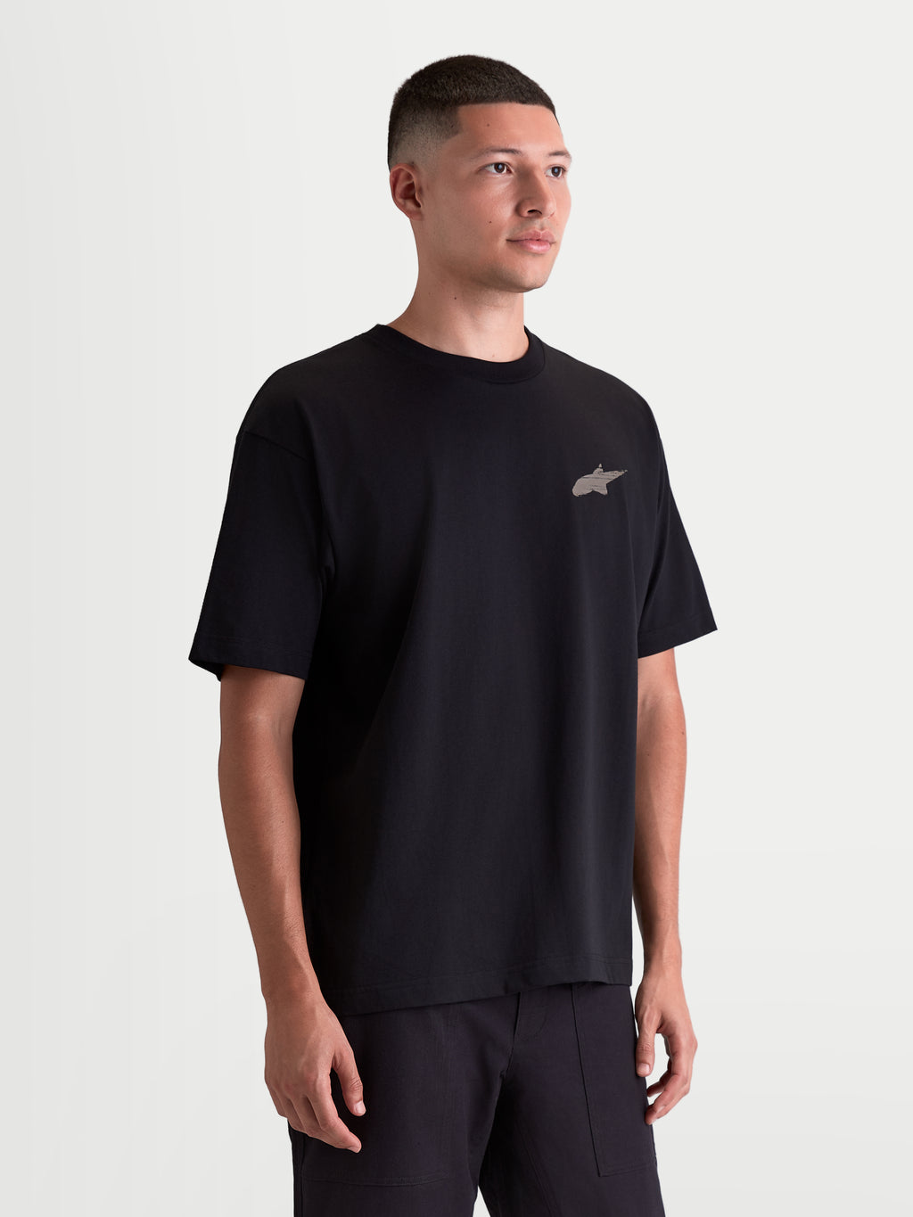 Alpinestars camiseta Checkback Oversized CSF, camiseta de mangas cortas para hombre, negra, vista en modelo con ajuste oversize relajado y pequeño logotipo Astars frontal, confeccionada en mezcla de algodón premium, ropa deportiva de estilo casual inspirado en el motorsport