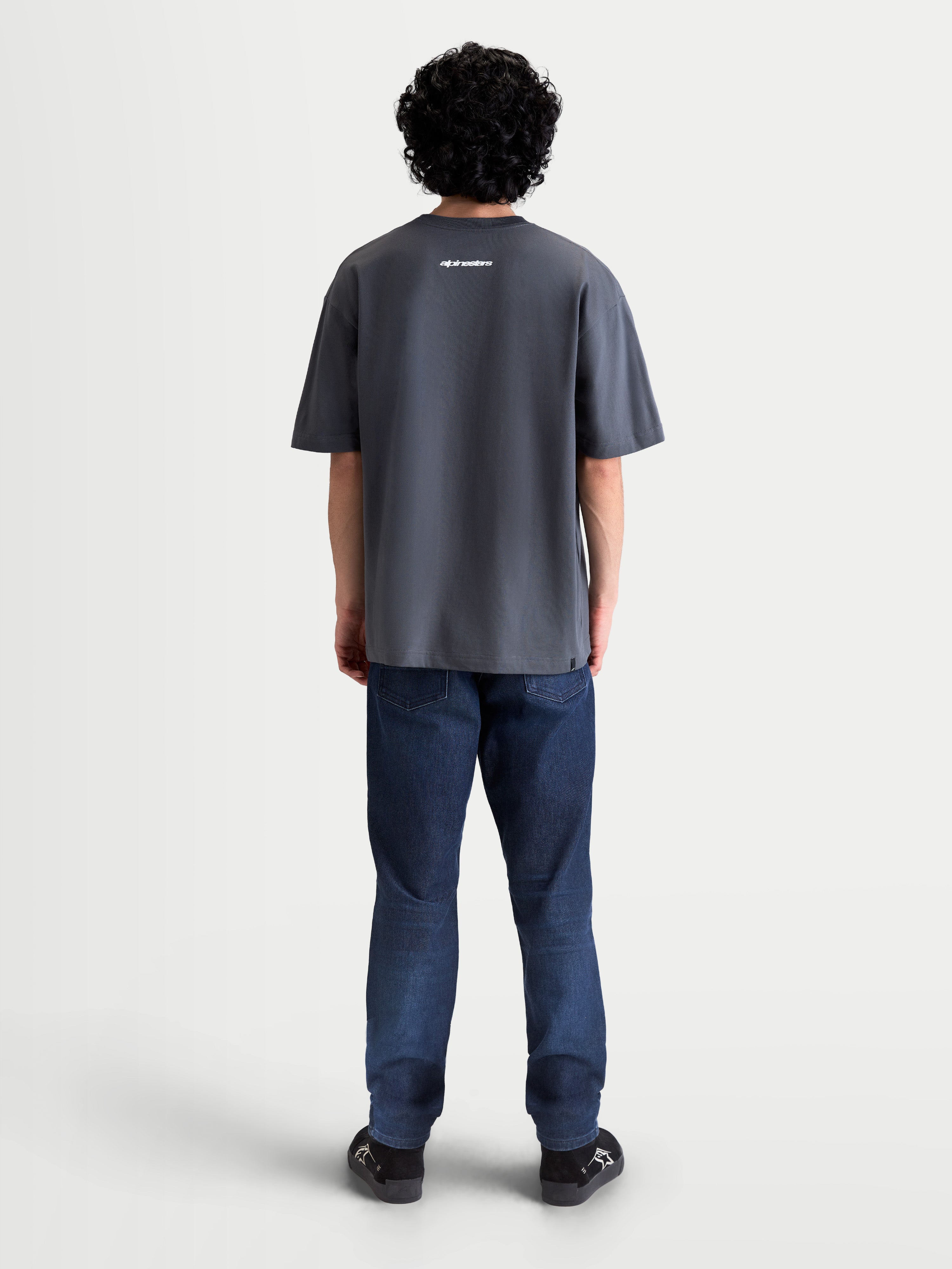 Alpinestars Mandate Oversized CSF, camiseta de mangas cortas gris, ropa deportiva unisex, vista trasera en modelo mostrando el gráfico wordmark blanco y ajuste oversized relajado, mezcla de algodón y poliéster.