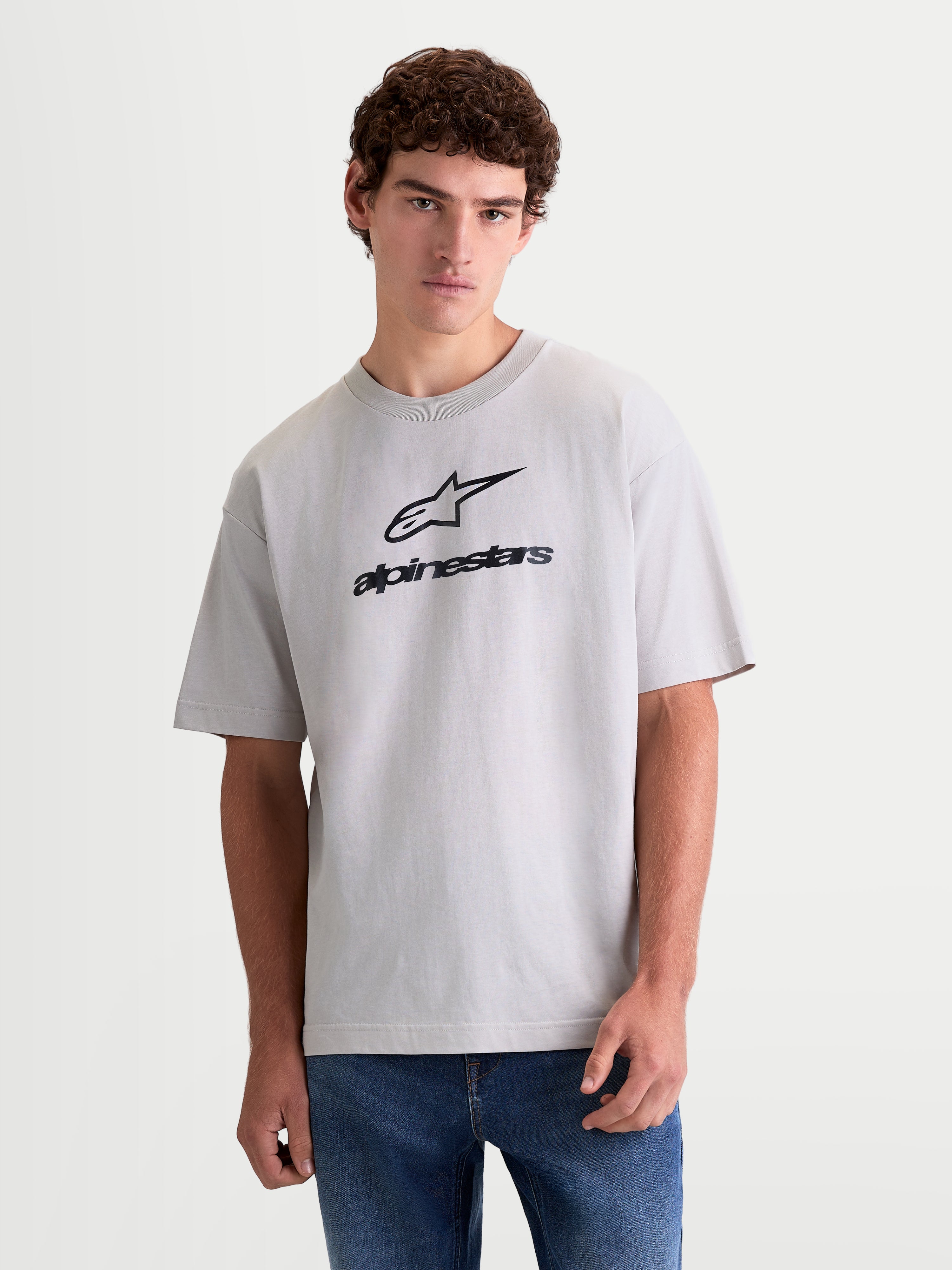 Alpinestars Prelude Oversized CSF, camiseta de mangas cortas para hombre y mujer, gris cemento con logotipo negro en el pecho, ajuste holgado para estilo casual diario, vista frontal con modelo