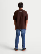 Alpinestars Prelude Oversized CSF, camiseta de mangas cortas para hombre, marrón, vista trasera en modelo con un pequeño logotipo blanco en la nuca, ajuste holgado oversized, ropa deportiva