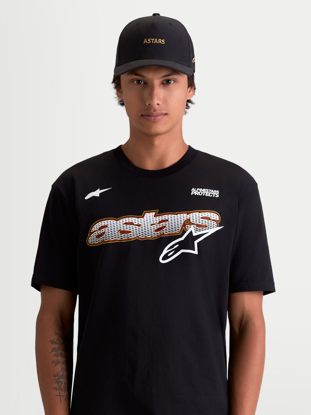 Alpinestars camiseta Cypress CSF, camiseta de mangas cortas para hombre, negra y blanca, con gráfico frontal Astars con relleno de malla y logotipo Alpinestars Protects, vista en modelo, estilo sportswear, tejido de algodón y poliéster premium