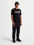 Alpinestars Camiseta Cypress CSF, camiseta de mangas cortas de ropa deportiva para hombre, negra con gráfico frontal Astars con relleno de malla y logotipo, mezcla premium de algodón y poliéster, vista de cuerpo completo en modelo