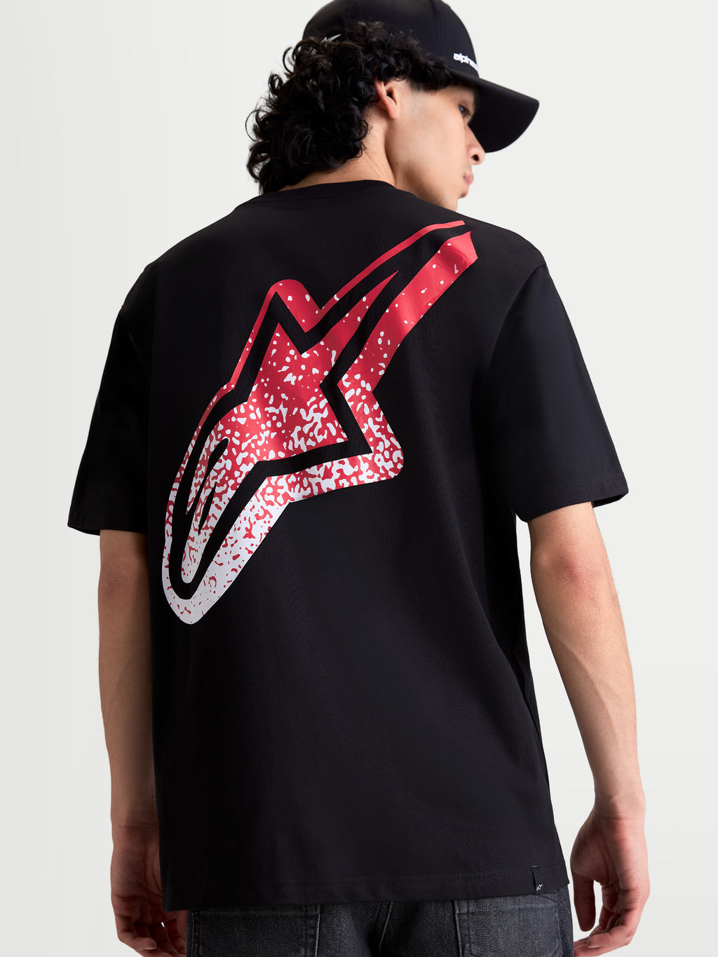 Alpinestars Meteor CSF, camiseta de mangas cortas para hombre, negra, vista trasera con gran logotipo Astars degradado en rojo y blanco inspirado en el MX, ropa casual de motorsport