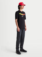 Alpinestars Camiseta Elliptogrit CSF, camiseta de mangas cortas para hombre, negra con gráfico frontal Astars en degradado amarillo y rojo y logotipo blanco, ropa deportiva de estilo casual