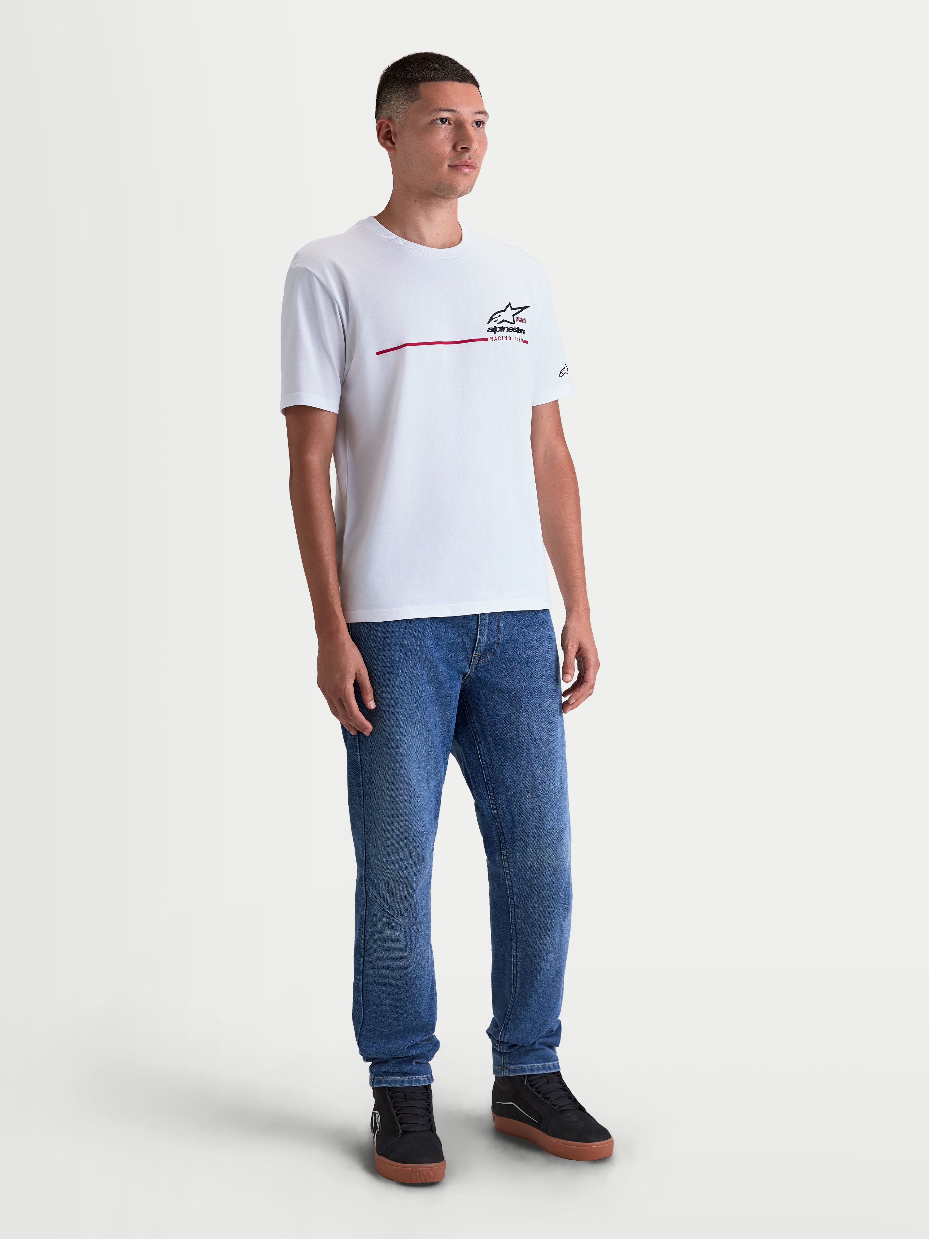 Alpinestars P1 CSF, camiseta de mangas cortas, ropa deportiva para hombre, blanca con gráfico frontal de raya de competición en negro y rojo, mezcla de algodón y poliéster, modelo vistiendo la prenda