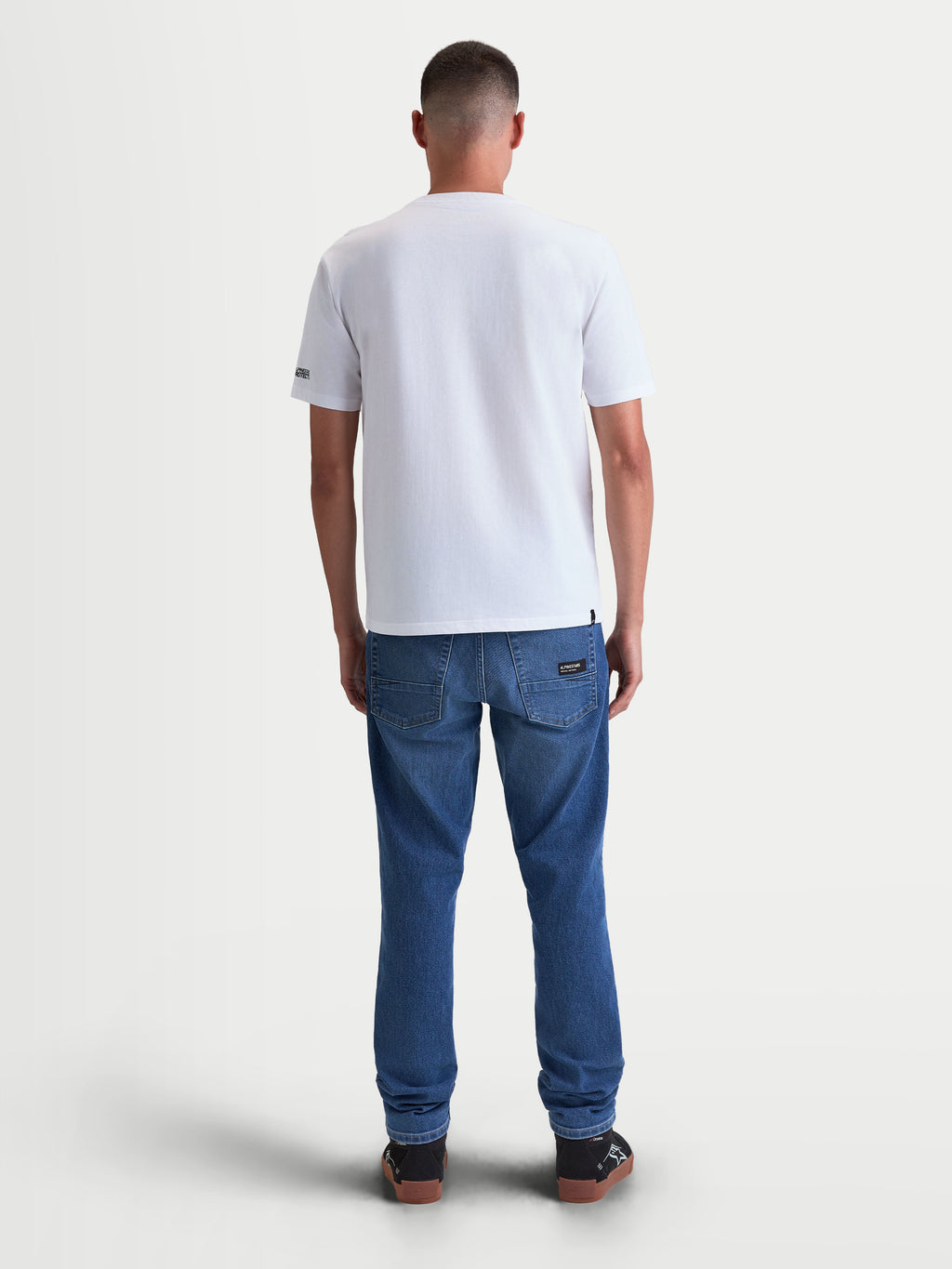 Alpinestars P1 CSF, camiseta de mangas cortas de estilo motorsport, blanca, unisex, vista trasera en modelo, confeccionada en mezcla de algodón y poliéster