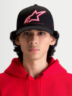 Alpinestars Lineout, gorra de béisbol para sportswear con visera curva, negra con logotipo Astars bordado en rojo y blanco y lema One Goal One Vision, vista frontal en modelo con sudadera roja, construcción de sarga estructurada.