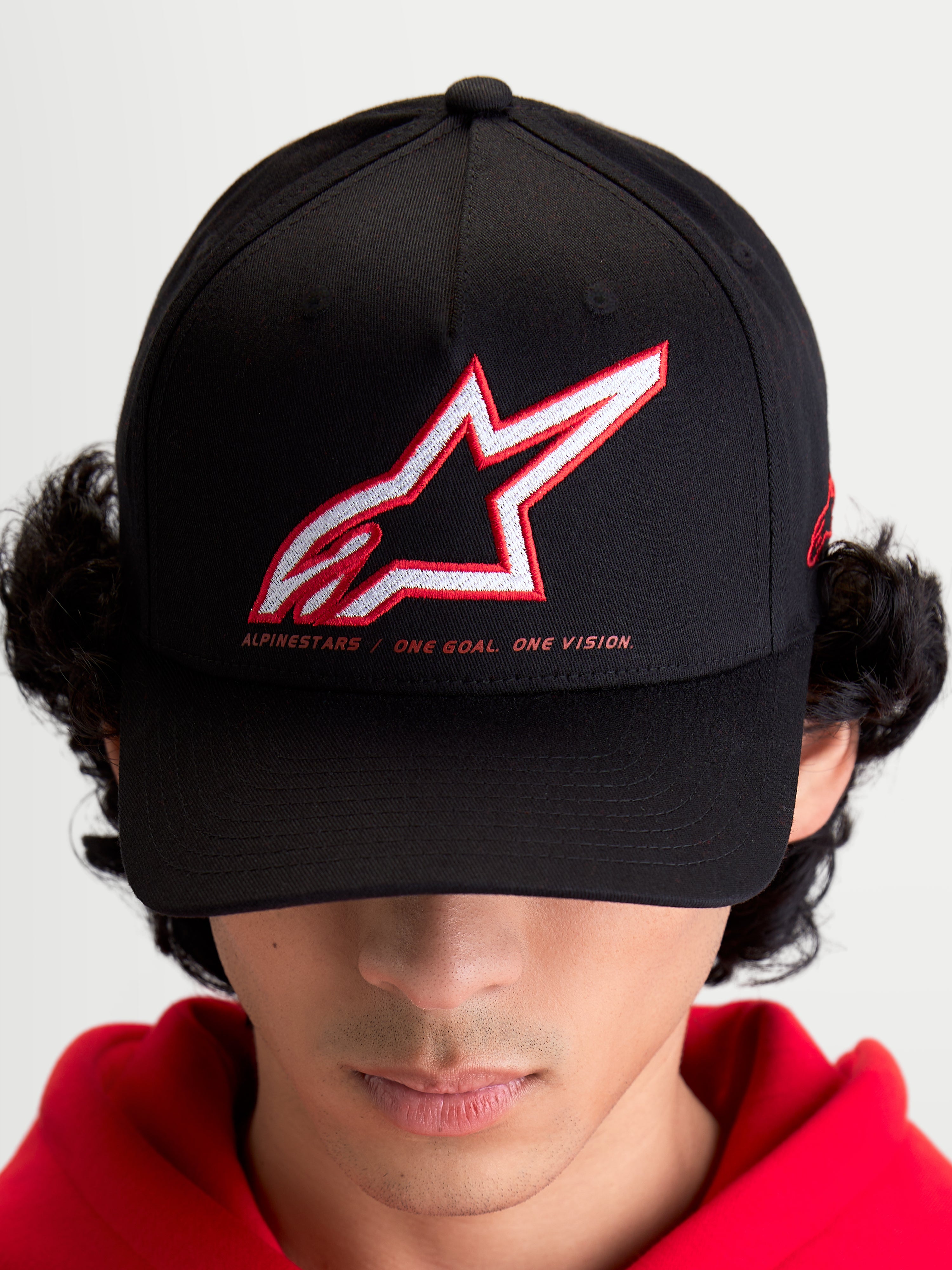 Alpinestars Gorra Lineout, gorra de béisbol de estilo sportswear para hombre y mujer, negra con logotipo Astars bordado en rojo y blanco y lema One Goal One Vision, visera curva y corona estructurada
