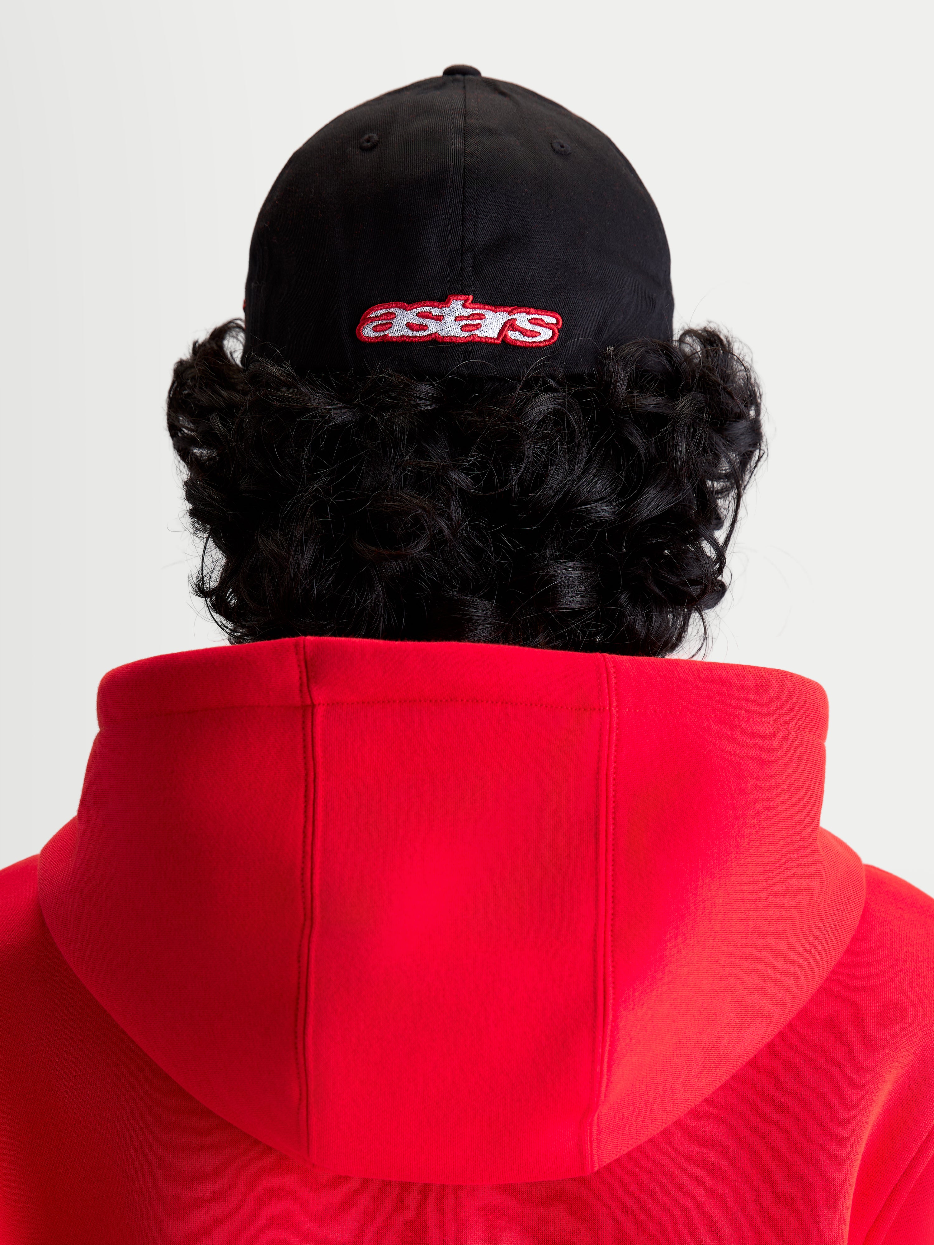 Alpinestars Gorra Lineout, gorra de béisbol de sportswear, negra y roja, vista posterior en modelo con logotipo Astars bordado, corona estructurada y construcción de tejido de sarga