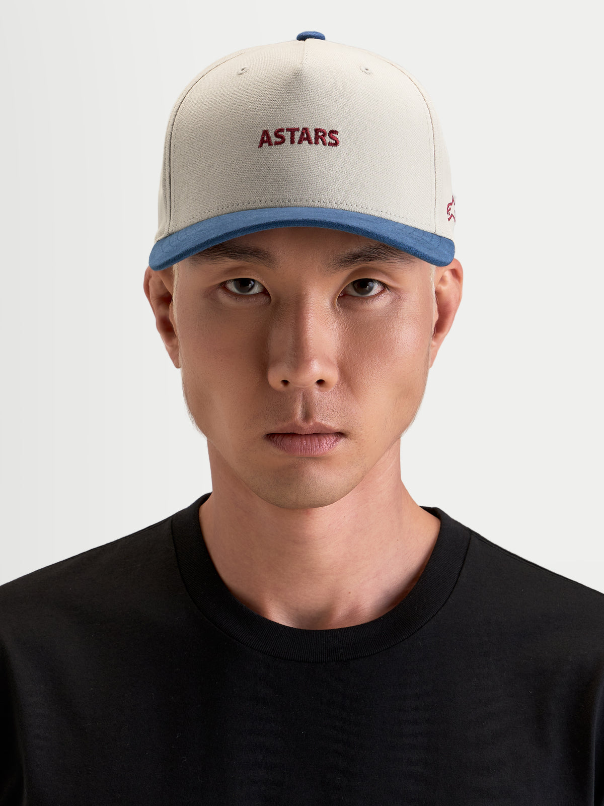 Gorra County Canvas Alpinestars, gorra sportswear casual, color arena y azul con logos bordados Astars frontal y lateral, corona estructurada y visera curva, vista frontal en modelo