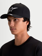 Alpinestars Arclight, gorra de estilo sportswear negra y blanca, con visera curva, corona estructurada y logotipo Astars blanco en relieve, mostrada en modelo.