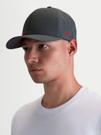 Alpinestars Gorro Points, gorra sportswear de visera curva sobre modelo, gris oscuro con logotipo rojo, nailon tactel ligero, ajuste flex-back para comodidad diaria