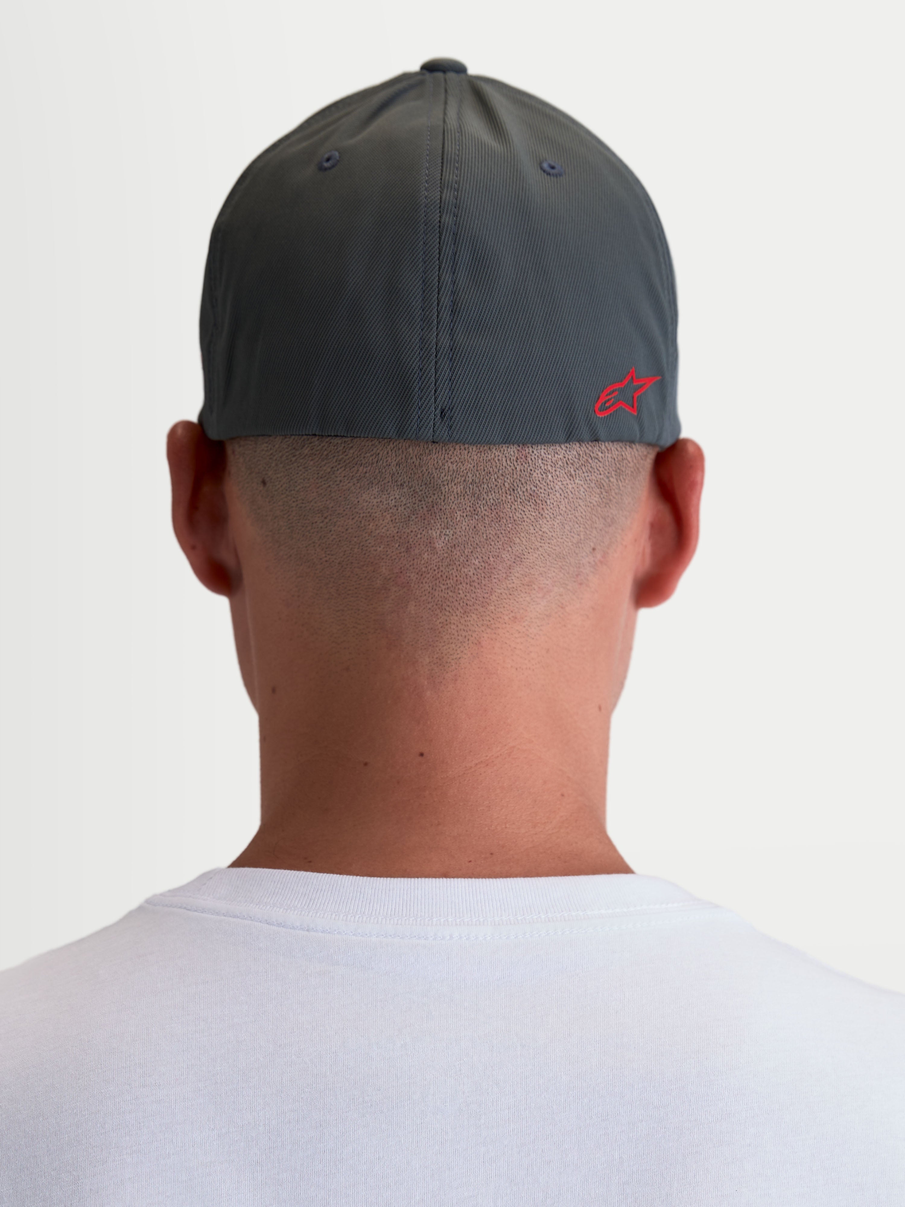 Alpinestars Gorro Points, gorra de estilo sportswear unisex, gris oscuro y rojo, tejido ligero de nylon tactel con ajuste flex-back, vista trasera sobre modelo con logotipo Astars rojo