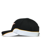 Alpinestars Gorra 500 Snapback, gorra de estilo motorsport y sportswear, unisex, negra y blanca con ribete naranja en contraste, vista lateral que muestra detalles de corte y confección, visera curva y corona estructurada de sarga de algodón.