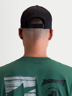 Alpinestars Gorra Algo Perf Ajustable, gorra snapback de motorsport, color negra, vista trasera en modelo con detalle del cierre ajustable, confeccionada en tejido técnico transpirable para uso deportivo y diario, unisex