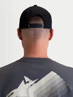 Alpinestars Gorra Combo Logo Snapback, gorra de estilo motorsport para hombre y mujer, negra, confeccionada en sarga de algodón duradera, vista trasera en modelo que muestra el cierre snapback ajustable y un pequeño logotipo blanco.