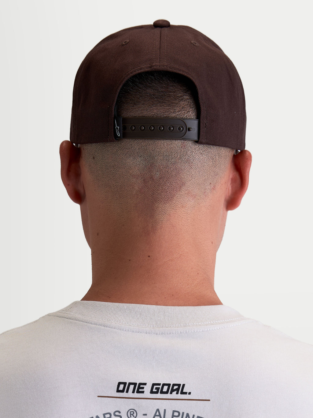 Alpinestars gorra Combo Logo Snapback, gorra de sarga de estilo motorsport casual, marrón, vista trasera en modelo que muestra el cierre snapback ajustable y la etiqueta de marca Astars.