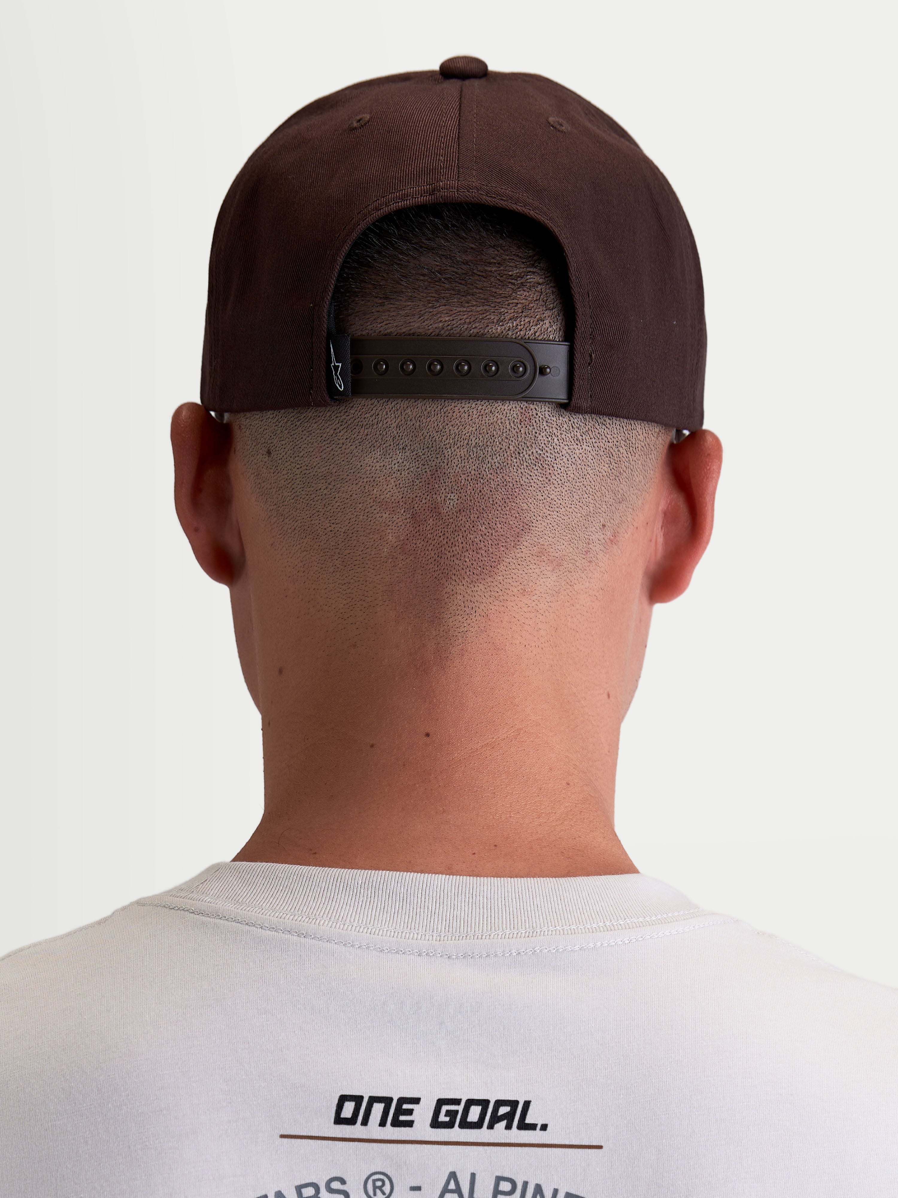 Alpinestars gorra Combo Logo Snapback, gorra de sarga de estilo motorsport casual, marrón, vista trasera en modelo que muestra el cierre snapback ajustable y la etiqueta de marca Astars.