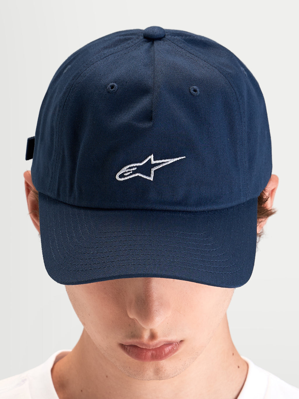 Alpinestars Gorra Dylan Dad, gorra deportiva casual azul de sarga con visera curva y logo Astars bordado en blanco, vista frontal en modelo