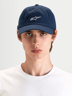 Gorra Dylan Dad Alpinestars, gorra deportiva casual azul marino con bordado del logotipo Astars en blanco, visera curva y corona baja no estructurada, vista frontal en modelo