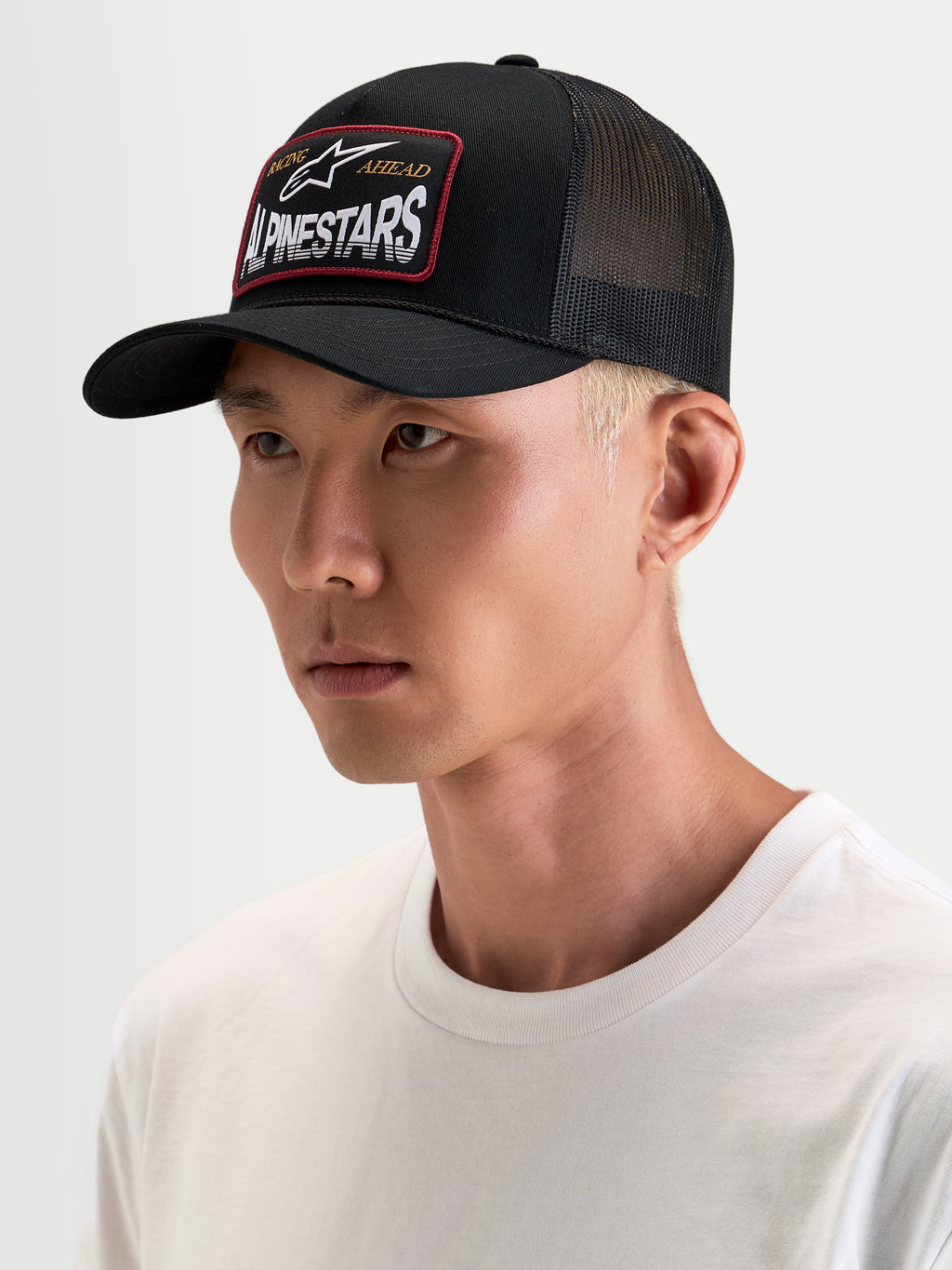 Gorra Hemmings Alpinestars, gorra trucker deportiva, negra con paneles traseros de malla transpirable y parche frontal con el logotipo tejido, vista en modelo