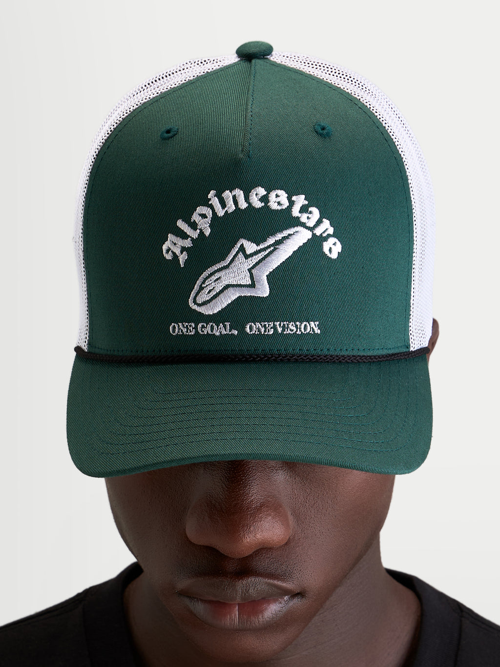 Alpinestars Gorra Baron, gorra trucker casual, verde y blanca, con visera curva, frontal de sarga estructurada y parte trasera de malla transpirable, vista frontal en modelo
