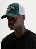 Alpinestars Gorra Baron, gorra trucker casual deportiva, verde y blanca, con visera curva, corona estructurada y logotipo delantero bordado, vista en modelo