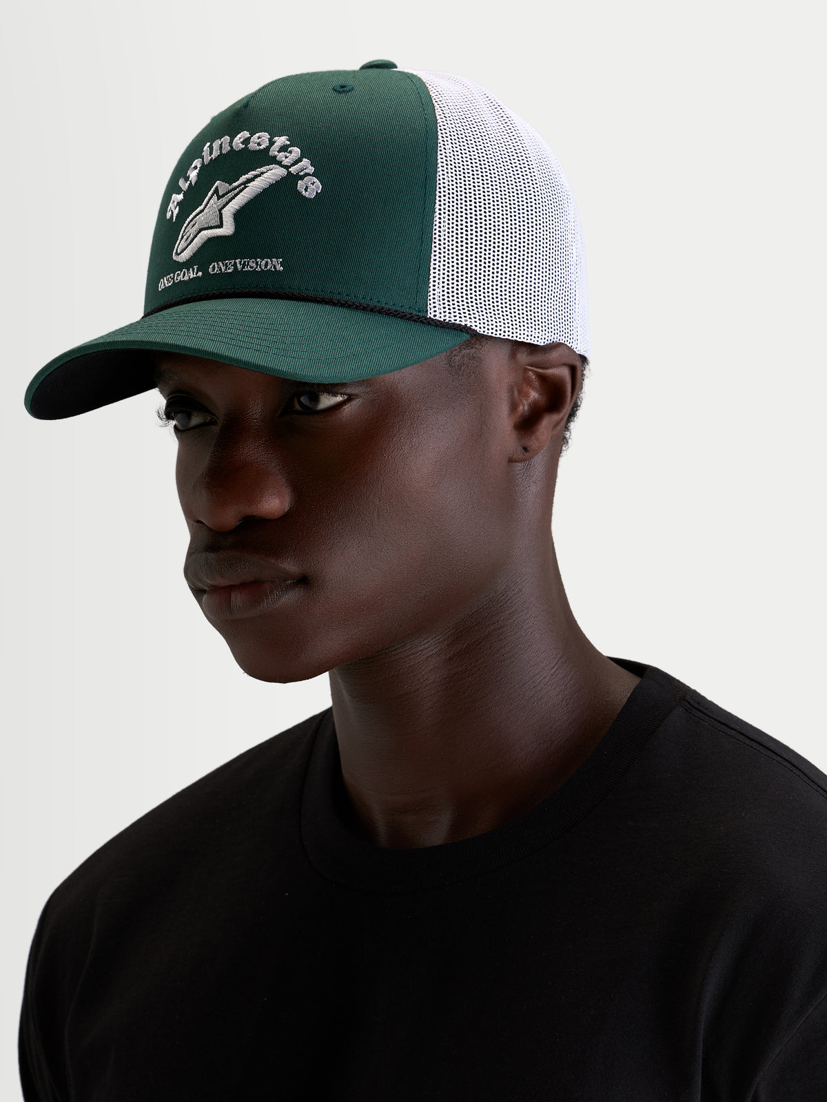 Alpinestars Gorra Baron, gorra trucker casual deportiva, verde y blanca, con visera curva, corona estructurada y logotipo delantero bordado, vista en modelo