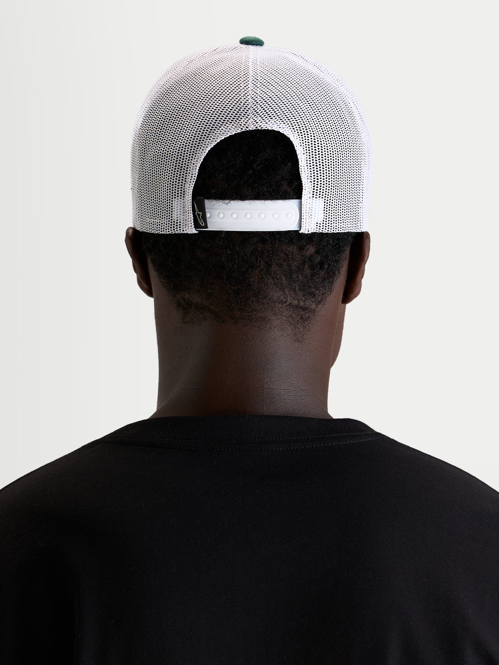 Gorra Baron Alpinestars, gorra trucker casual, blanca y verde con cierre ajustable a presión, vista trasera en modelo
