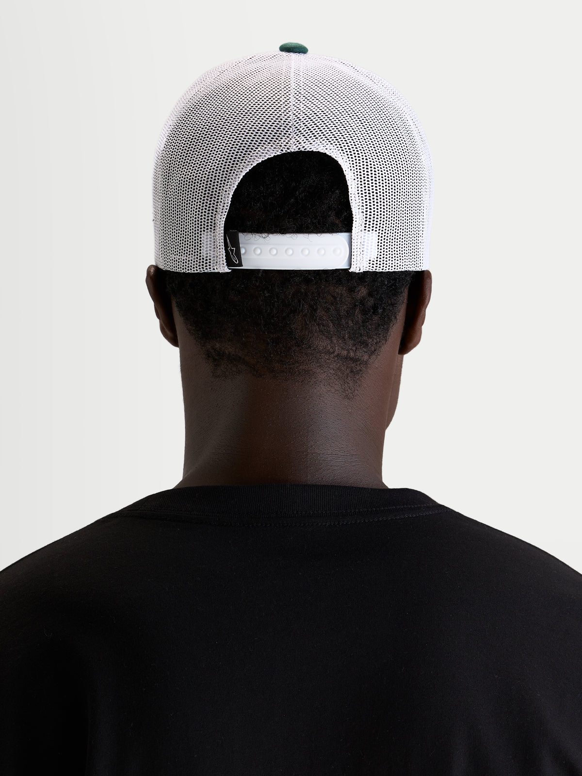 Gorra Baron Alpinestars, gorra trucker casual, blanca y verde con cierre ajustable a presión, vista trasera en modelo
