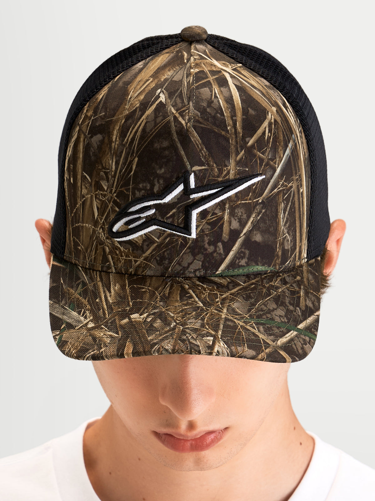 Gorra Thicket Realtree Alpinestars, gorra trucker sportswear con estampado de camuflaje Realtree y negro, visera curvada, corona estructurada y logo Astars bordado en blanco en el modelo