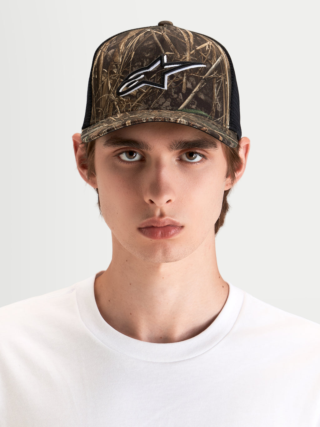Gorra Thicket Realtree Alpinestars, gorra trucker sportswear con patrón de camuflaje y negro, corona estructurada y logo Astars bordado, vista frontal en modelo