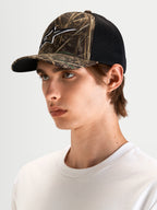 Gorra Thicket Realtree Alpinestars, gorra trucker sportswear de estilo outdoor, color camuflaje Realtree y negro, con visera curva y logotipo bordado, vista en modelo