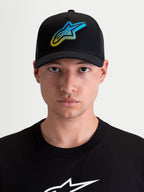 Alpinestars Meteorite, gorra de estilo sportswear con visera curva para hombre y mujer, negra con un parche del logotipo Astars de textura gravel en azul y amarillo, frontal de sarga y panel trasero de malla, vista frontal en modelo