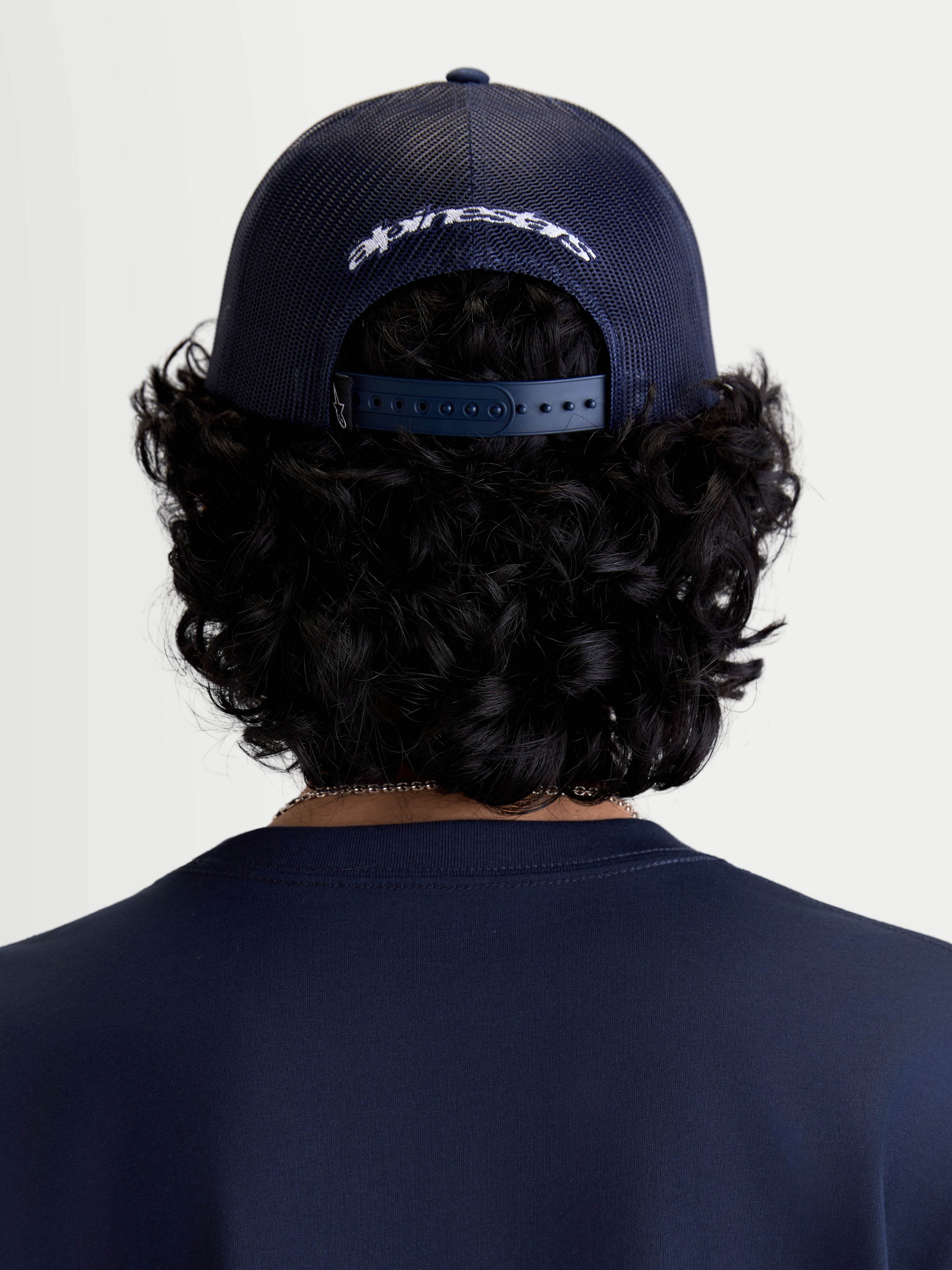 Alpinestars Gorra Meteorite, gorra de estilo casual, azul marino, paneles de malla trasera y cierre snapback ajustable, marca Alpinestars bordada en blanco, vista trasera sobre modelo.