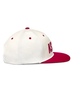 Alpinestars Stadium Snapback, gorra de visera plana y corona estructurada, blanca y roja, perfil lateral de sarga.