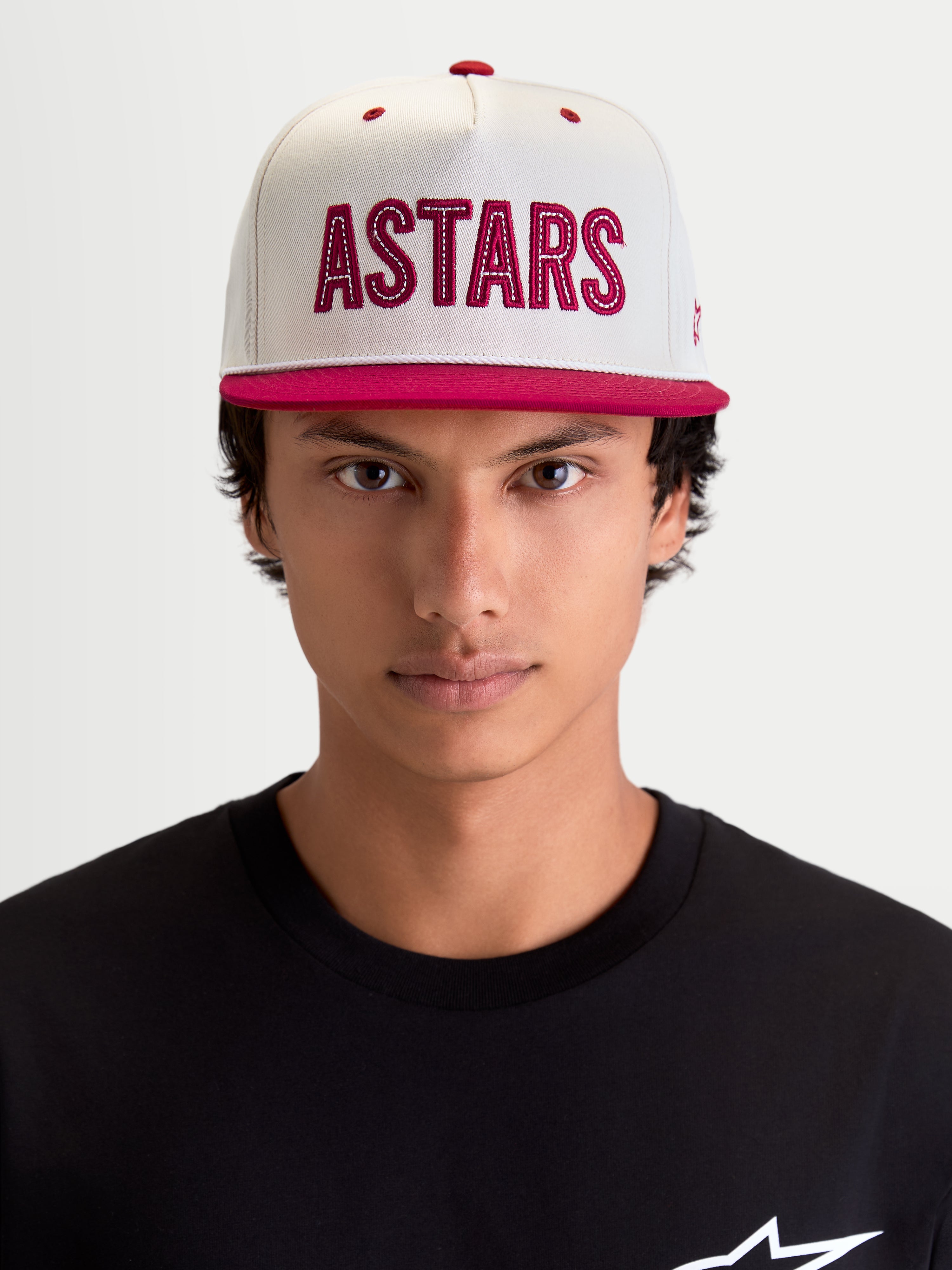 Alpinestars Stadium Snapback, gorra de ropa deportiva para hombre, blanco roto y rojo, vista frontal en modelo con visera plana, corona estructurada y aplique del logotipo ASTARS con costura en contraste